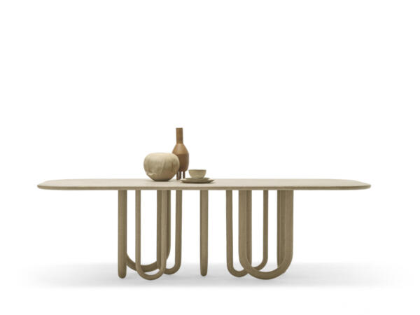 Ein moderner Esstisch mit einer ovalen Tischplatte und einer ungewöhnlichen Basis aus gebogenen Stützbeinen, die an Schlangen erinnern und ein geschwungenes, skulpturales Design bilden.
